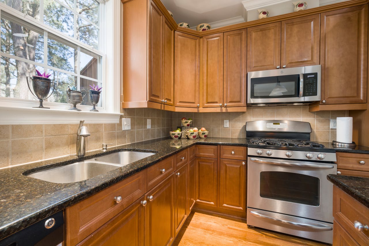home-hero A well-lit modern kitchen featuring wooden cabinets and stainless steel appliances.